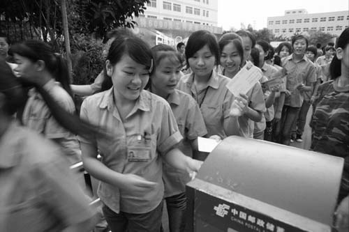 Young workers from Baoan District send postcards to their hometowns. [Photographed in 2009] 