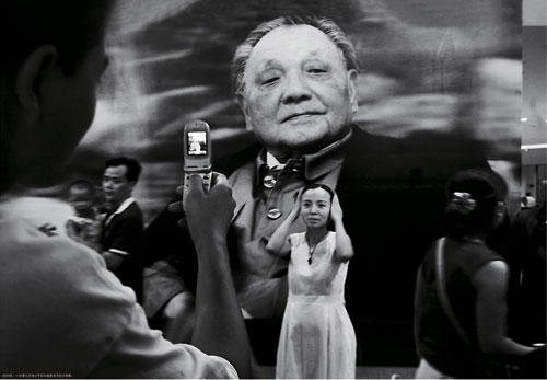 A young worker has her photo taken at Deng Xiaoping&apos;s centenary birthday celebration. [Photographed in 2004]
